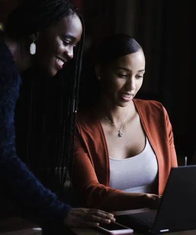 Two women using a laptop.